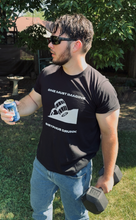 Load image into Gallery viewer, Man outdoors holding a can and dumbbell, wearing a black t-shirt with graphic design.